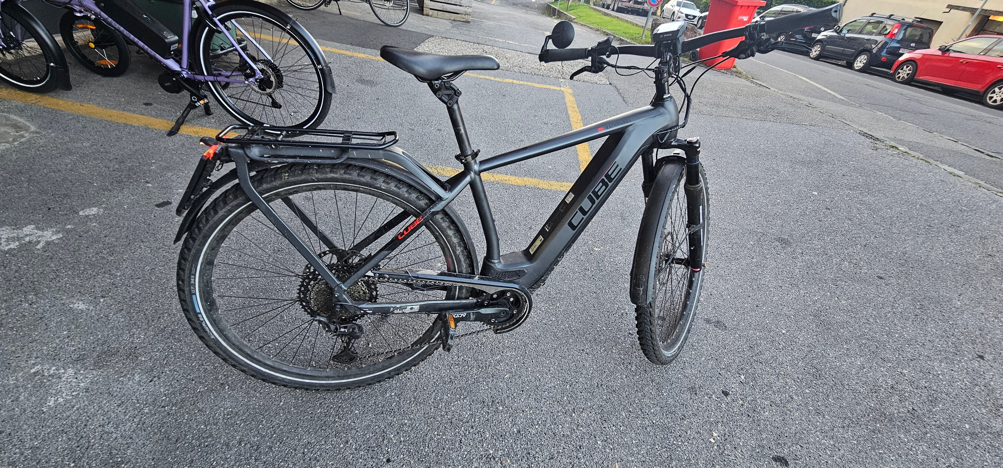 CUBE Kathmandu Hybrid 45 electric bike with Bafang 500W kit, Shimano XT 11-speed, telescopic fork, Magura 4-piston brakes, integrated stop light, and rear rack.