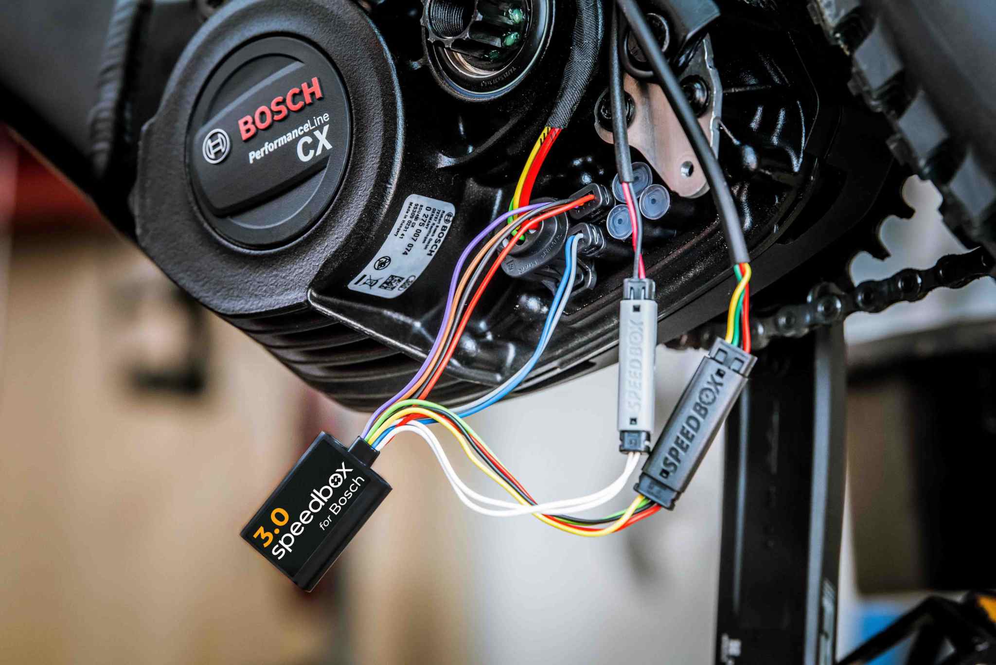 SpeedBox 3.0 tuning module connected to Bosch Performance Line CX e-bike motor with multicolored plug-and-play wires